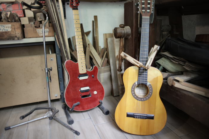 A red electric and yellow acoustic guitar side-by-side. Which is better for beginners?