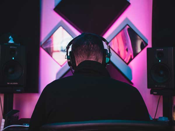 Man working in music studio with headphones on.
