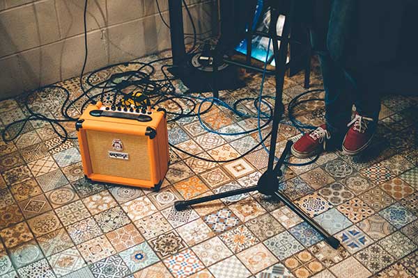 Person standing near Orange guitar amp