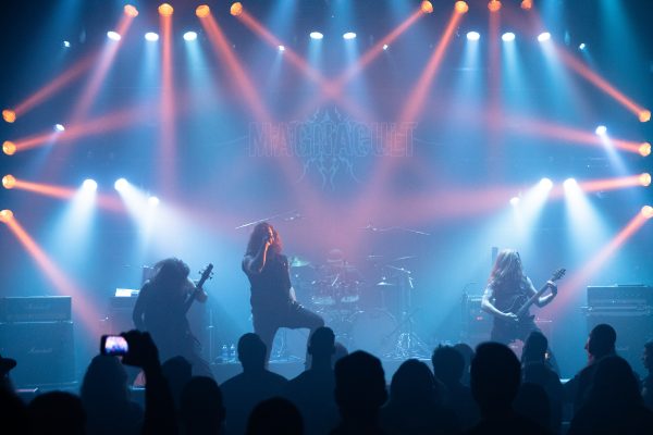 Metal band playing at concert.