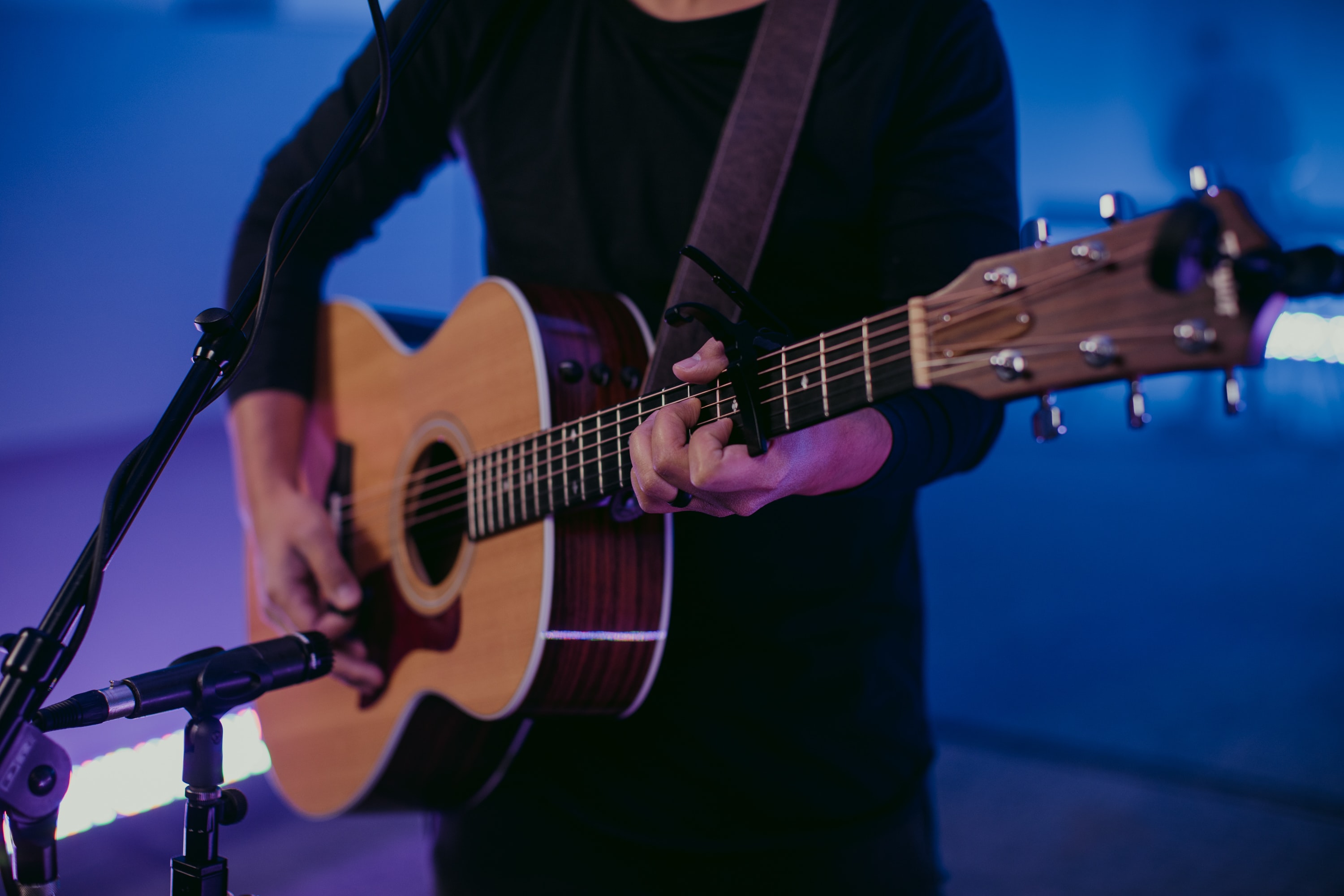 Man playing acoustic guitar. Best guitar effects pedals for acoustic guitar.
